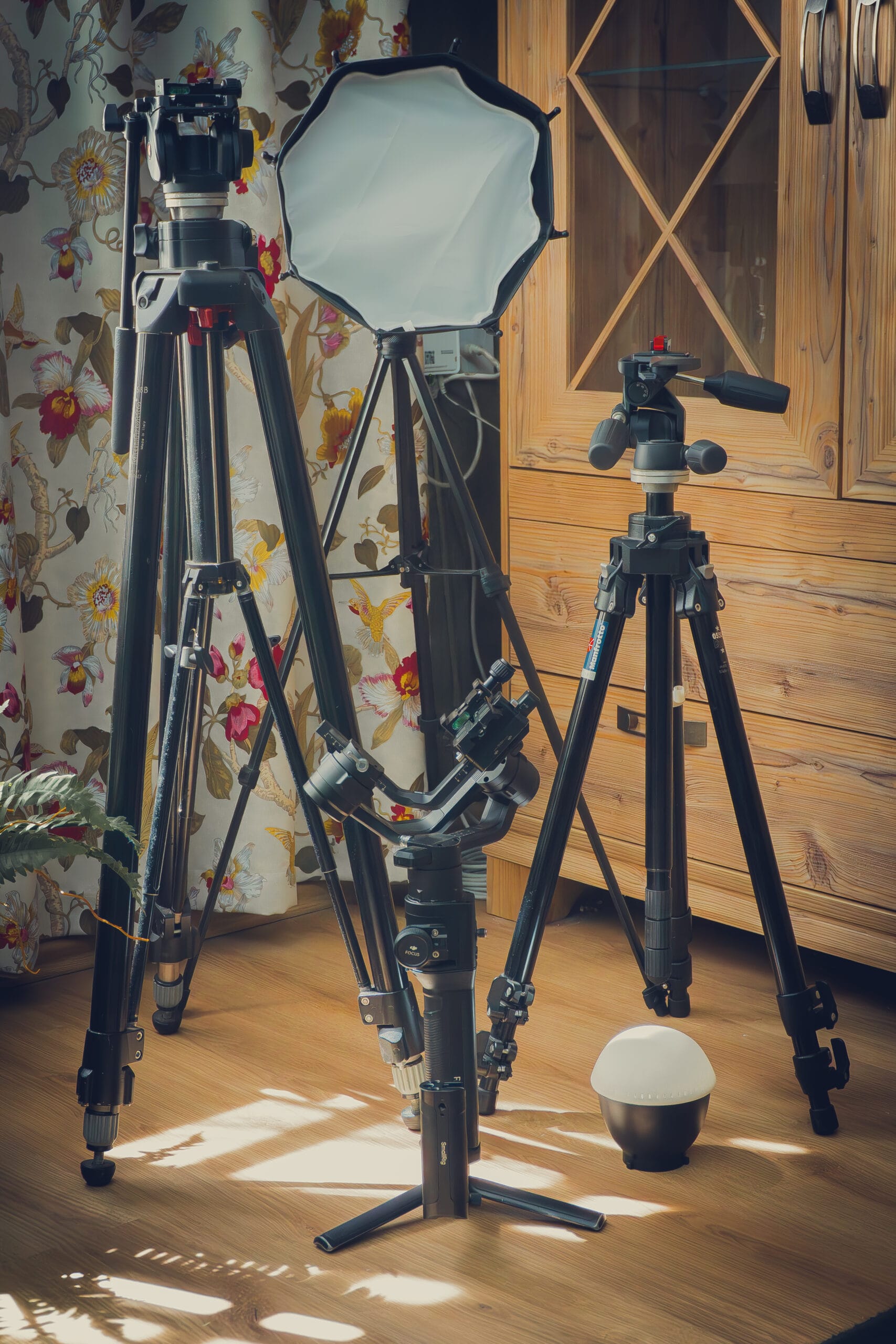 Dwa statywy fotograficzne, softbox i stabilizator (gimbal) na drewnianej podłodze – Obiektywni Studio
