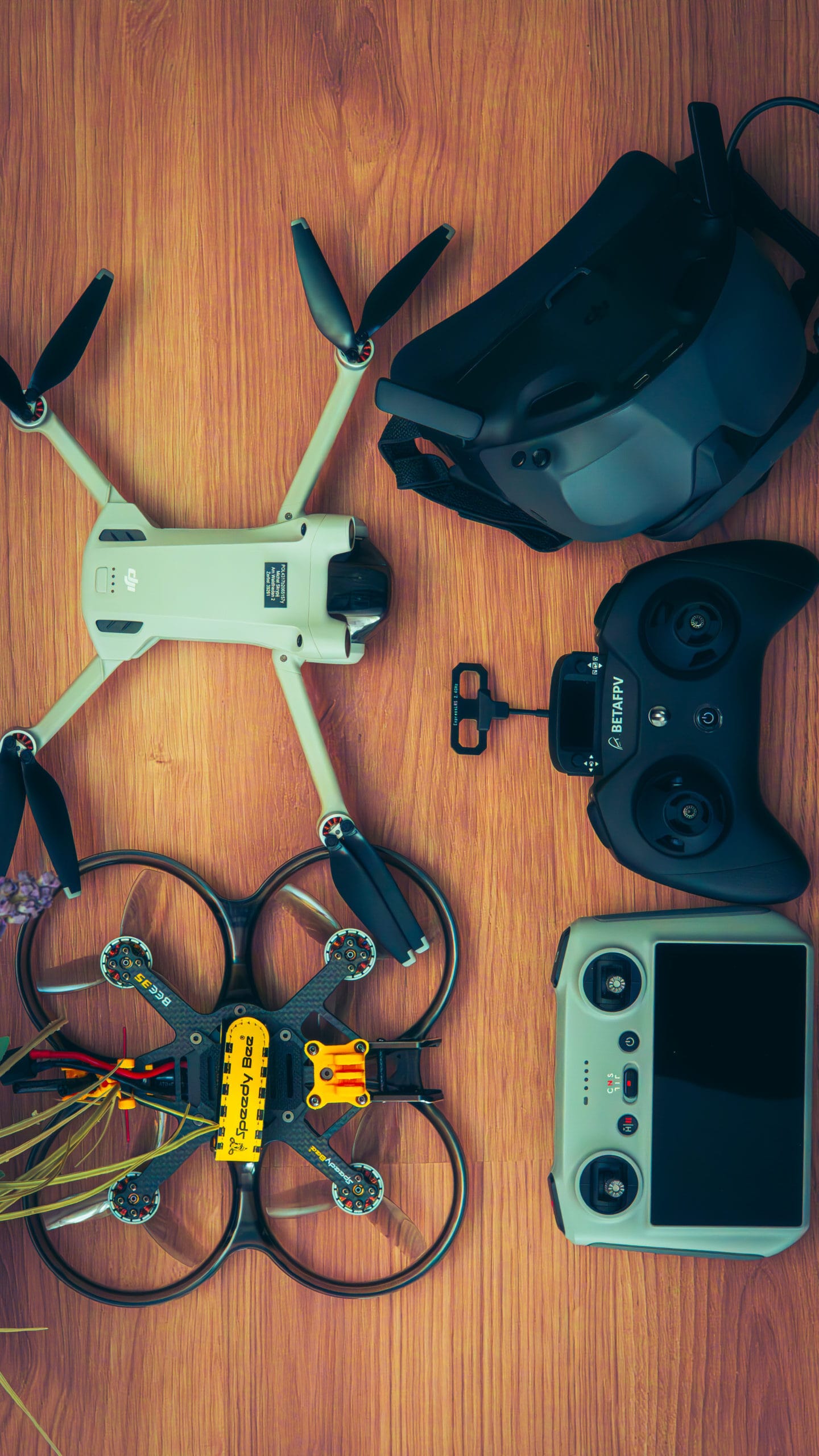 Drony DJI, gogle FPV i kontrolery na drewnianym stole – Obiektywni Studio